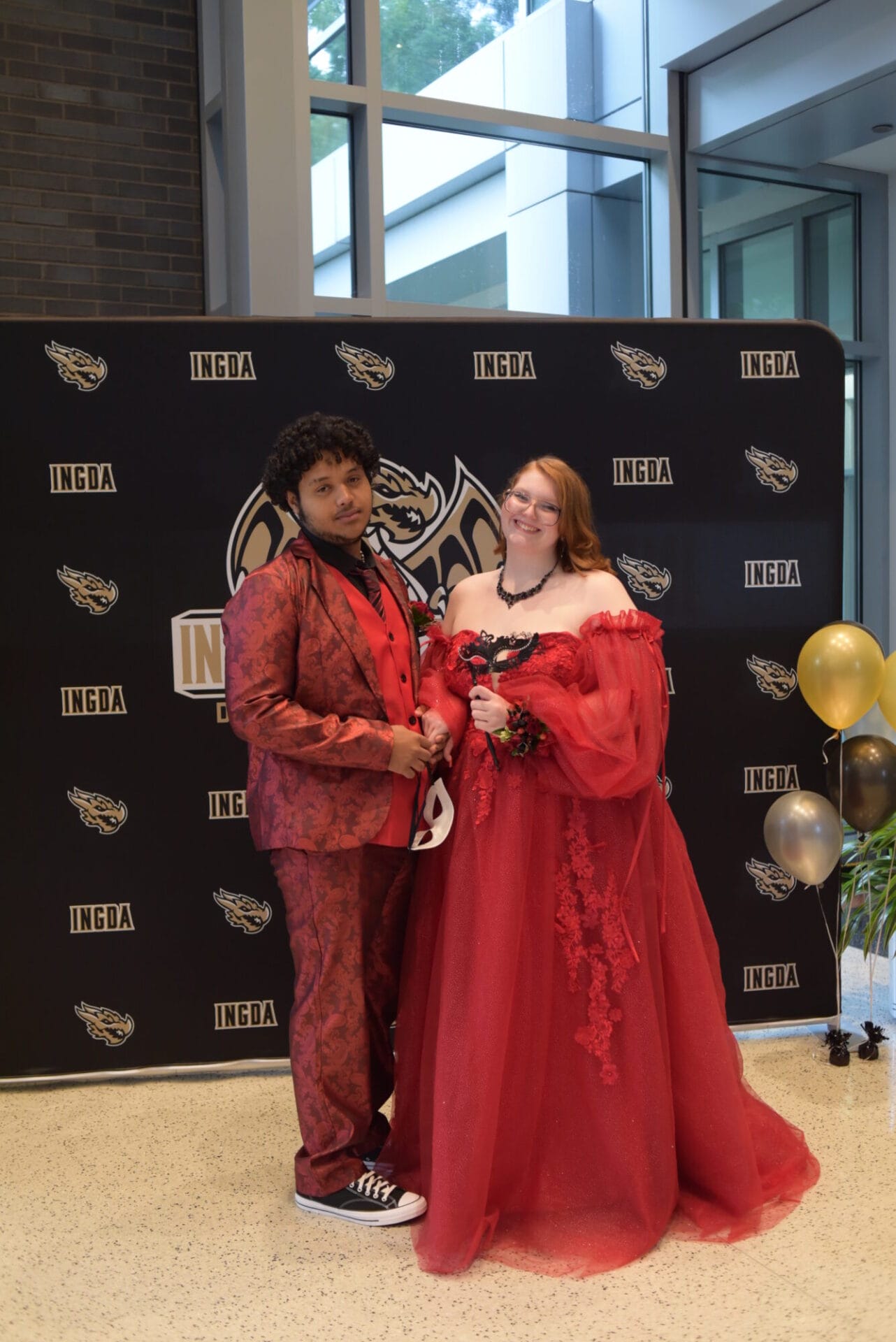 Students wearing red dress and a red suit at their prom