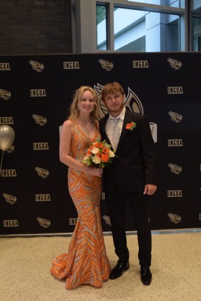 Students attending to their prom together and holding flowers